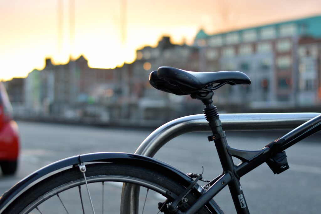 Bicycle against a city at sunset