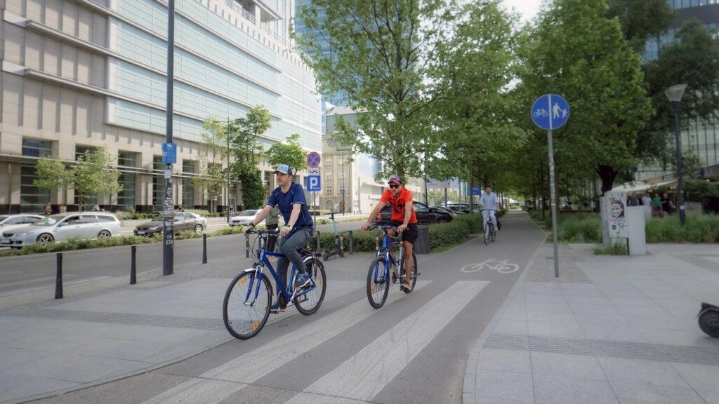 Two cyclists in the city on a bike lane, from Surprising_Shots from Pixabay.