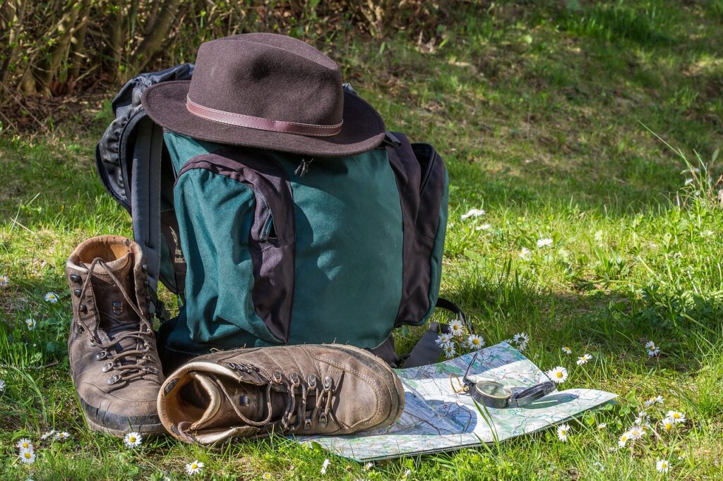 Hike pack, boots, hat, on the grass by Maxmann from Pixabay