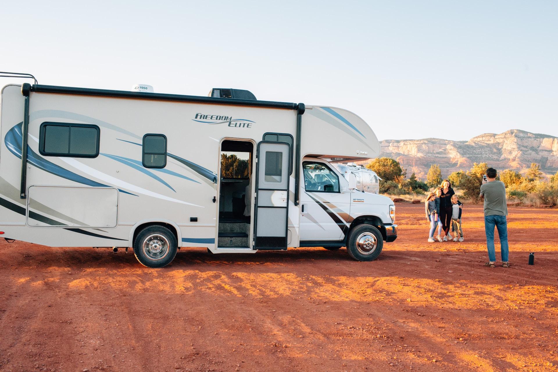 Lance Travel Trailer in the outdoors next to a family of travelers taking a picture