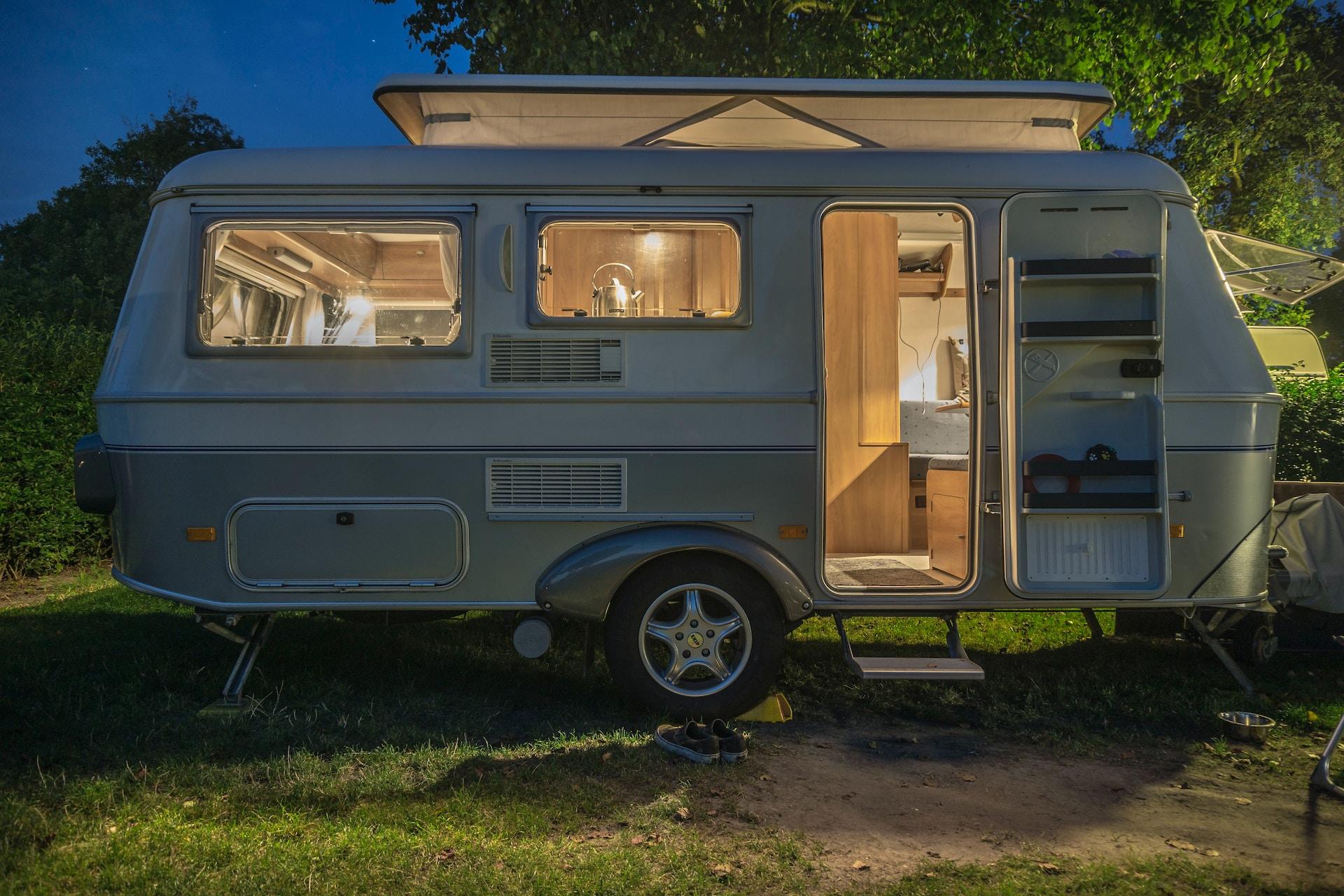A Dutchmen Travel Trailer all lit up in the evening.