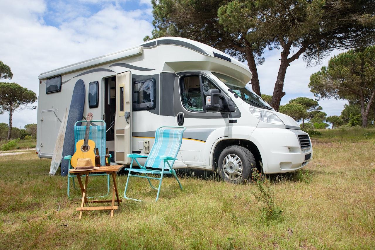 A Grand Design Travel Trailer in the middle of the wilderness, with surfboards and deck chairs