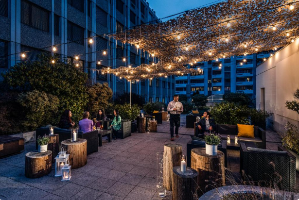 People enjoying dinner at Crowne Plaza Zurich rooftop terrace